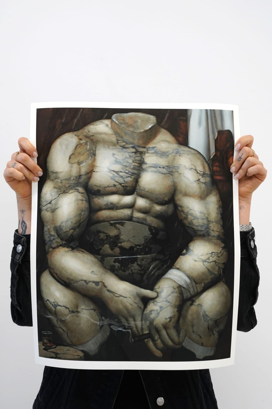 photo of a person holding up an art print by elliot purse featuring a seated boxer made out of marble