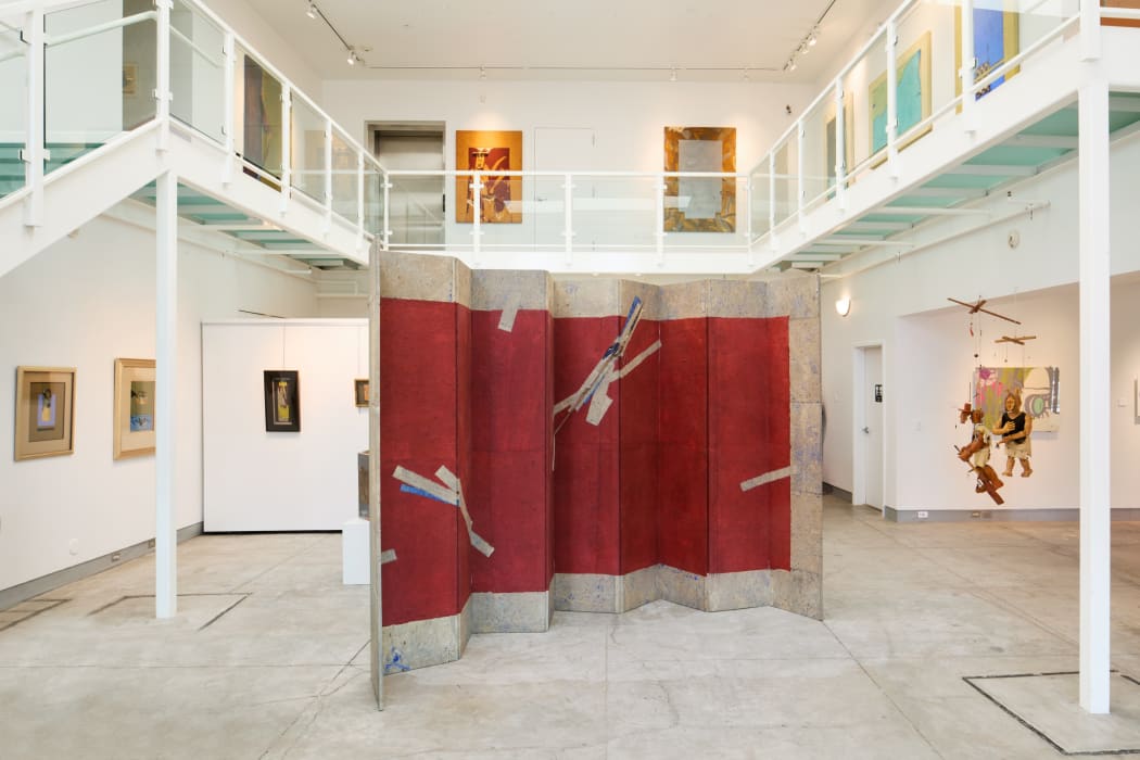 Folding screen amongst abstract paintings
