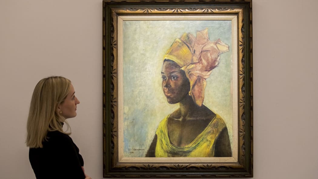 picture of a woman looking at the painting Christine by Ben Enwonwu before the Bohnams 2019 Modern and Contemporary African Art sale in London