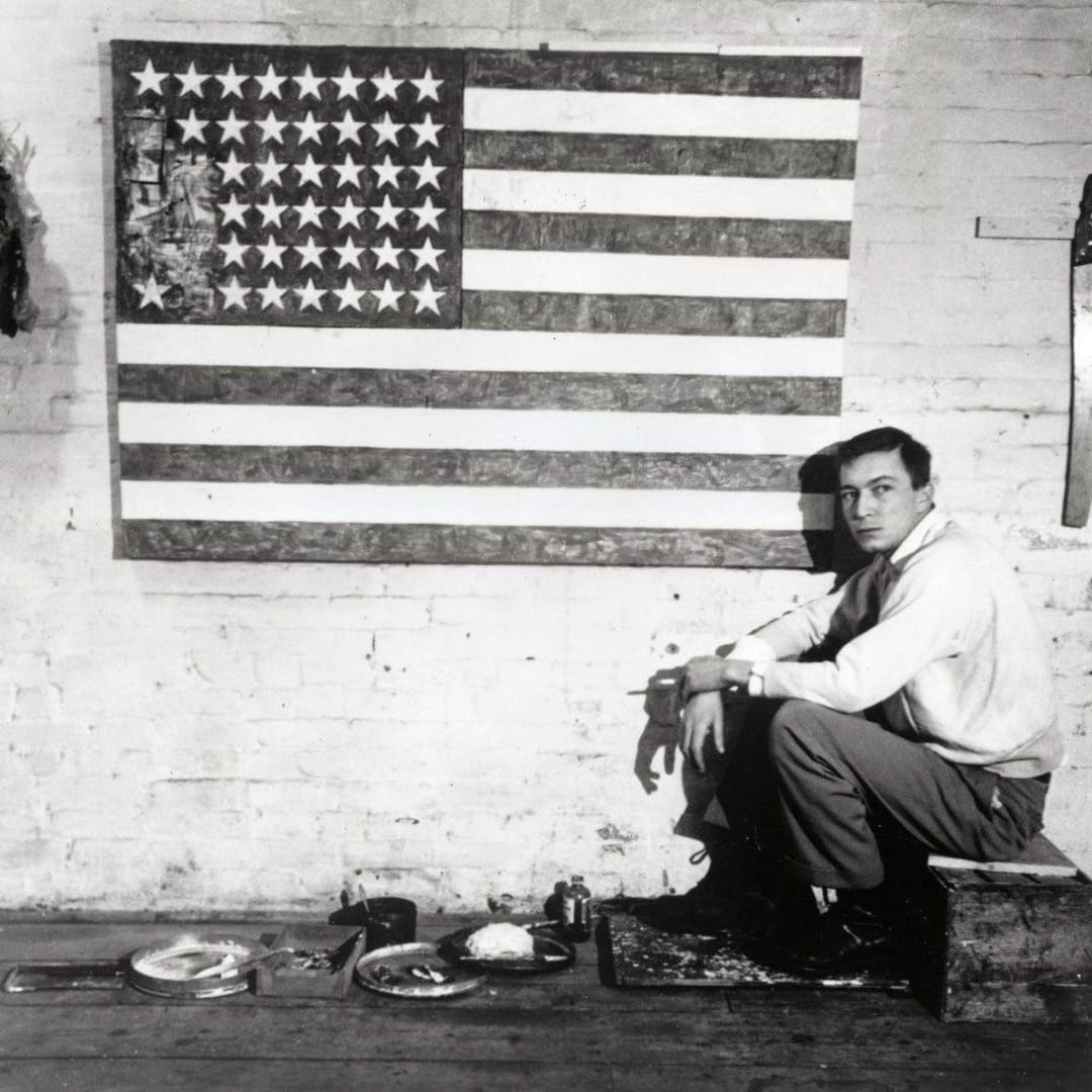 Jasper Johns in his studio on Pearl Street with Flag, 1954-55, New York. Photograph by Robert Rauschenberg.