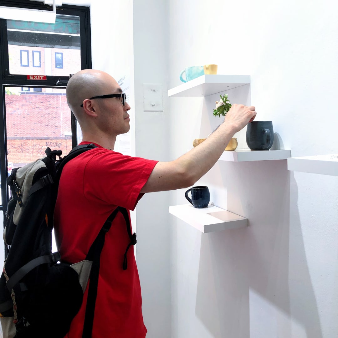 A gallery visitor interacting with Si Jie Loo's installation