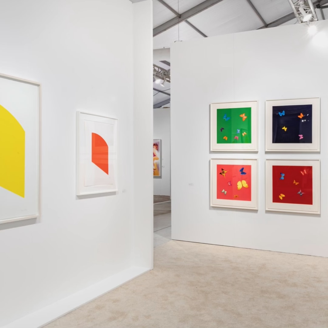 Image of portion of fair booth featuring prints by Ellsworth Kelly and Love Poems by Damien HIrst