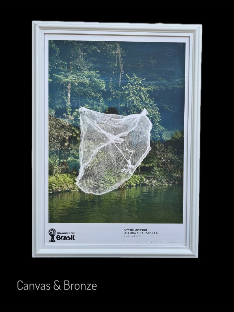 Framed art print by Allora & Calzadilla featuring a white net suspended in a lush green forest setting with a tranquil water body, showcasing a blend of nature and art."