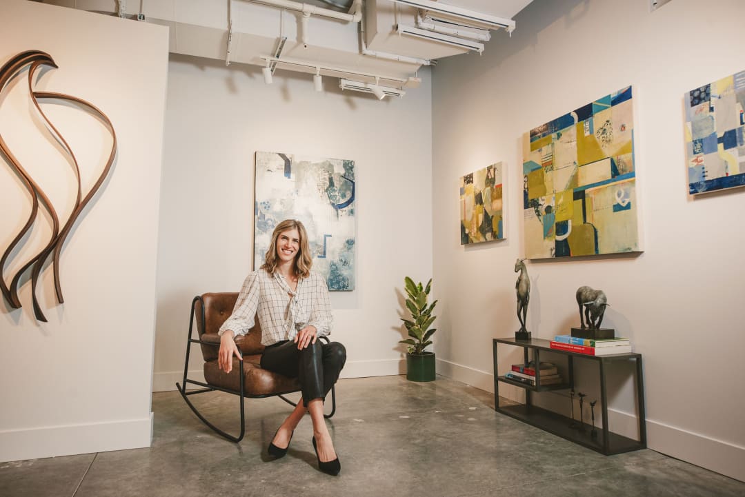 Victoria Kennedy at Kennedy Contemporary sitting in a chair next to a Heather Zusman sculpture