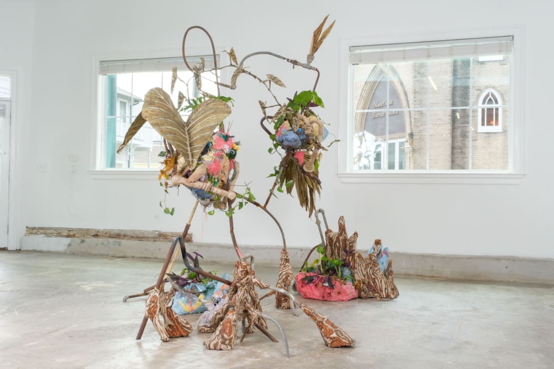 Hannah Chalew, Bottomland Chimera, 2023 metal, sugarcane, disposable plastic waste, lime, recycled paint, paper made from sugarcane combined with shredded disposable plastic waste (“plasticane”), ink made from brick, copper, goldenrod, fossil fuel pollution, indigo, oak gall, and sheetrock, soil, living plants, 90" x 115" x 85." Photo by Stephen Lomonaco.