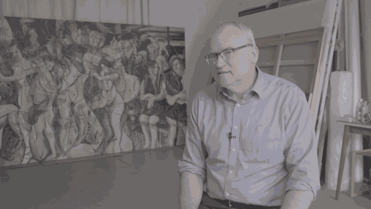Clive Head sitting in front of one of his artworks.
