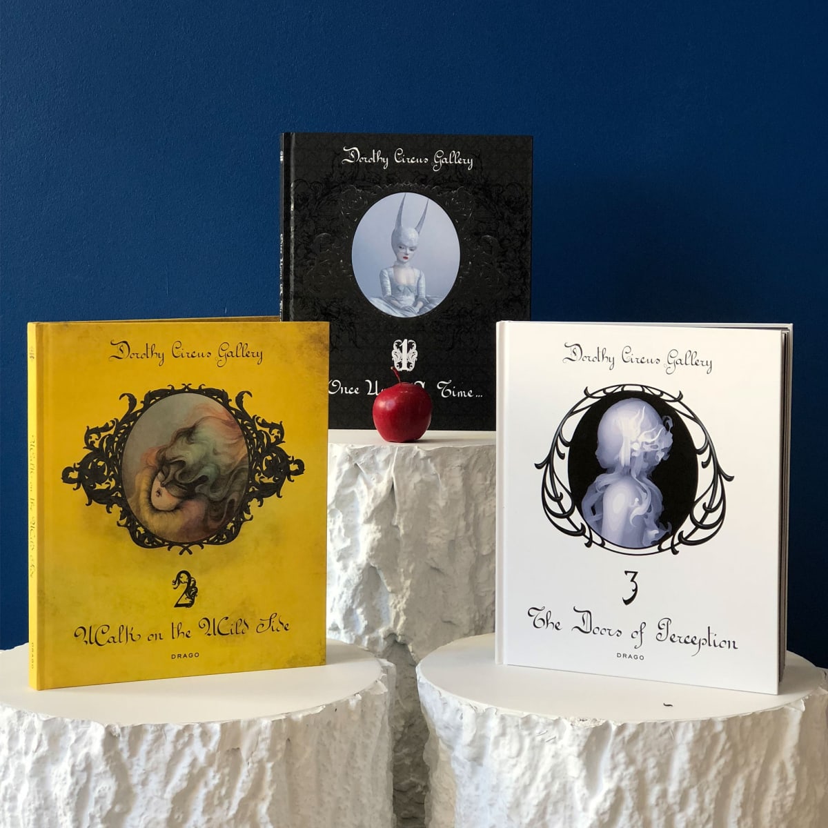 Trilogy Art catalogues published by Dorothy Circus Factory showing on the cover artworks by Miss Van, Ray Caesar and Kazuki Takamatsu