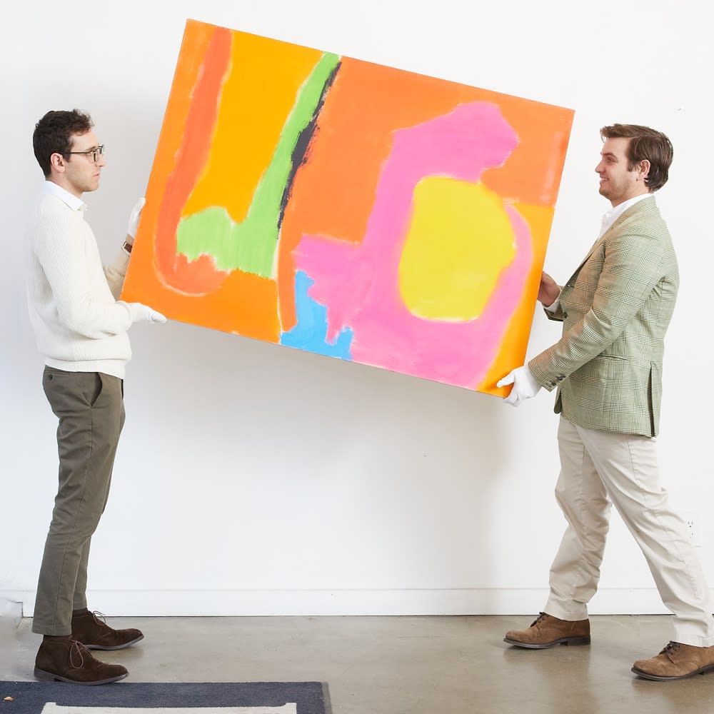 two men raising a bright and colorful painting