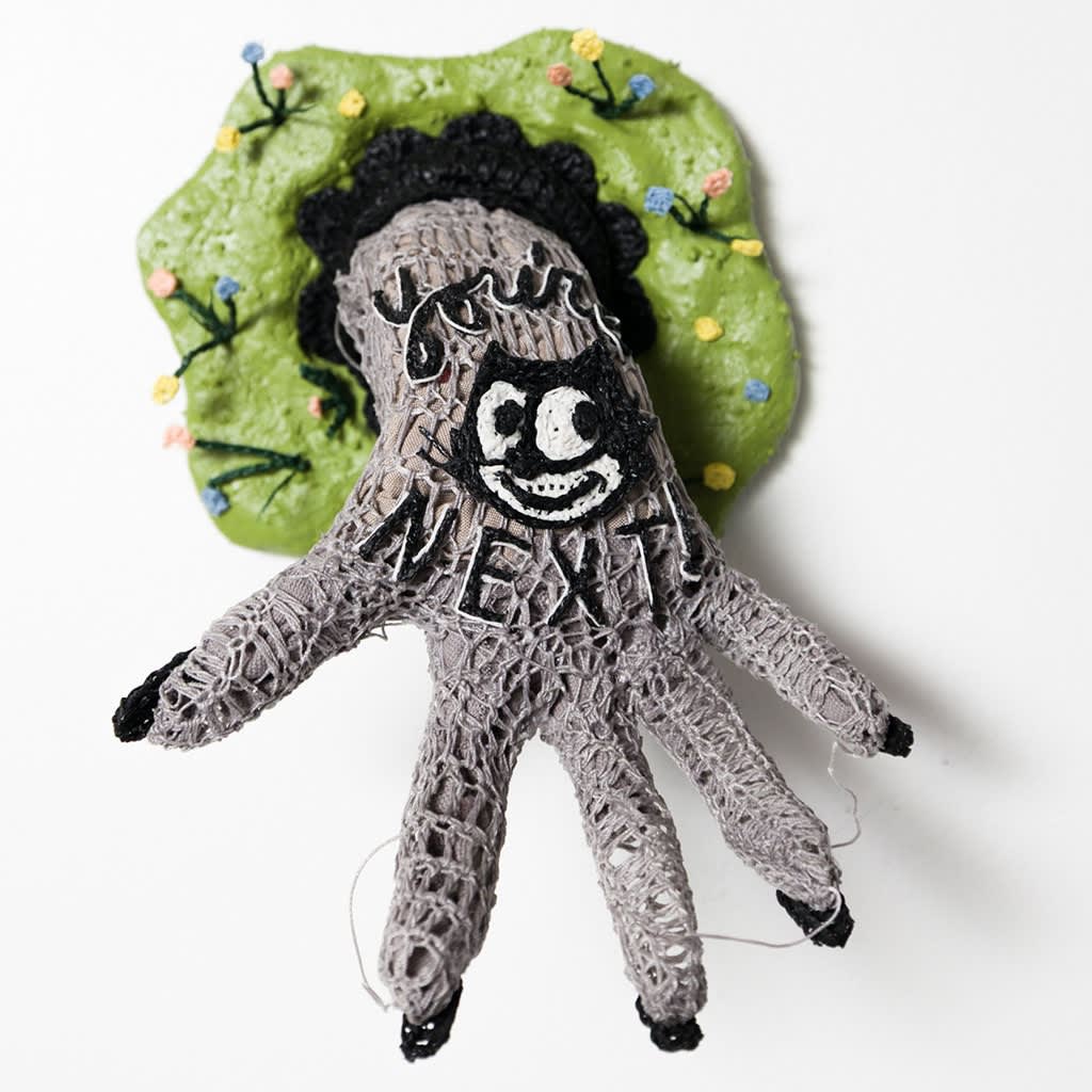 Caitlin McCormack crocheted sculpture of hand with Felix the Cat and 'you're next' written on it