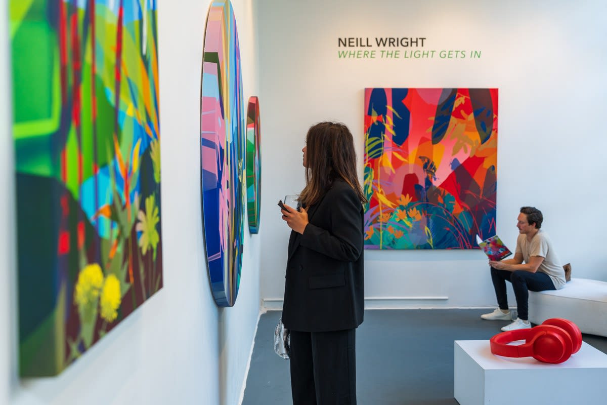 Woman staring at artwork by Neill Wright in Carousel Fine Art's Miami gallery space during Neill Wright's exhibition "Where the Light Gets In."