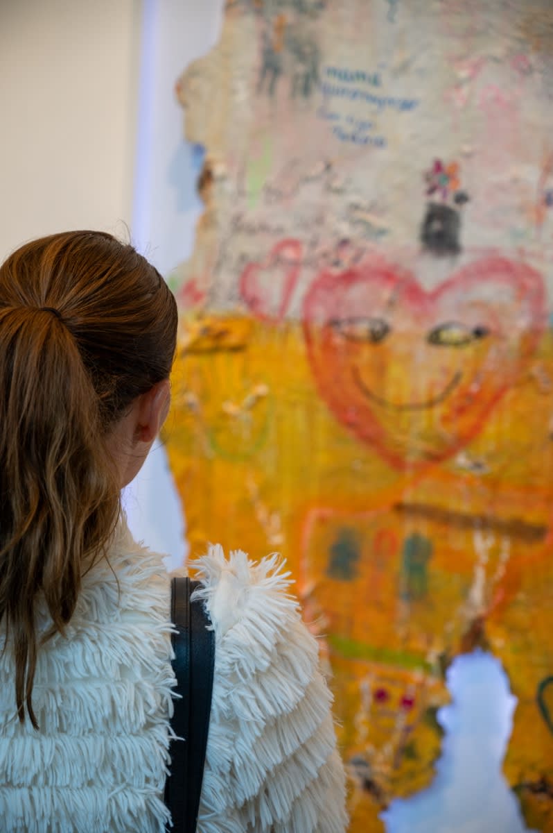 Woman staring at artwork by Justin Garcia in Carousel Fine Art's Miami gallery space