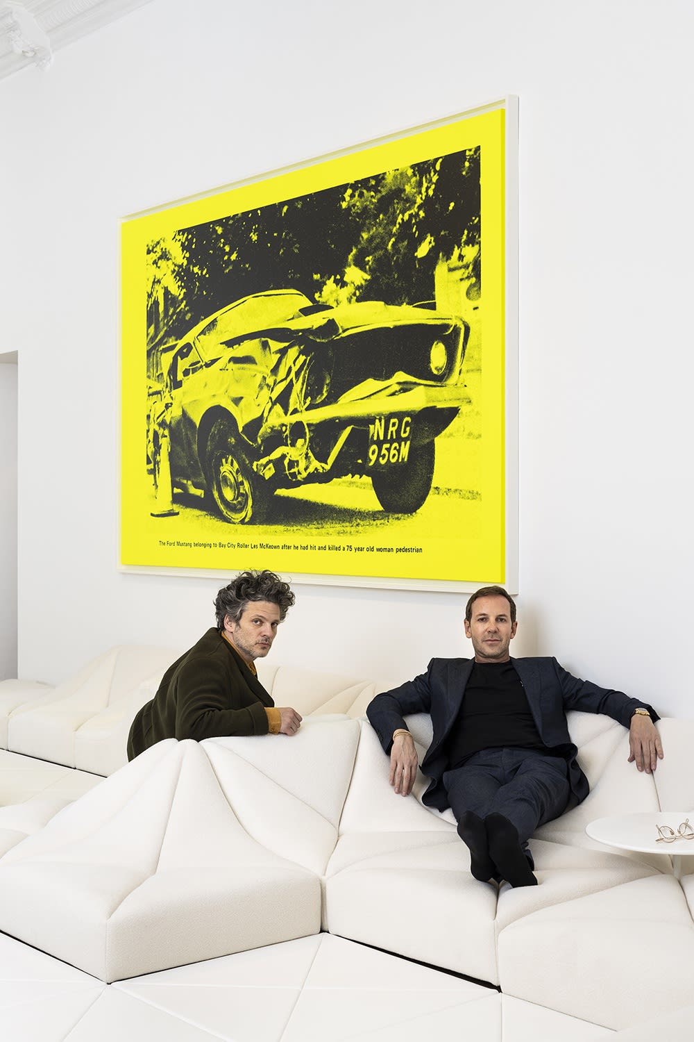 Charles Riva and Pierre Paulin seated on the Dune sofa with NRG, 2013 by Steven Shearer.