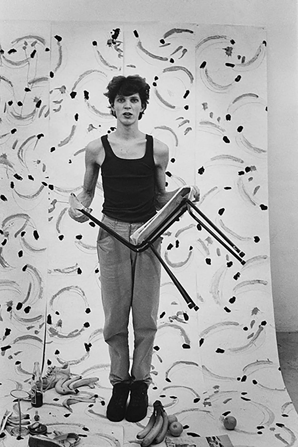 Erwin Olaf's first photo shoot as a young man holding a chair with backdrop with painted bananas