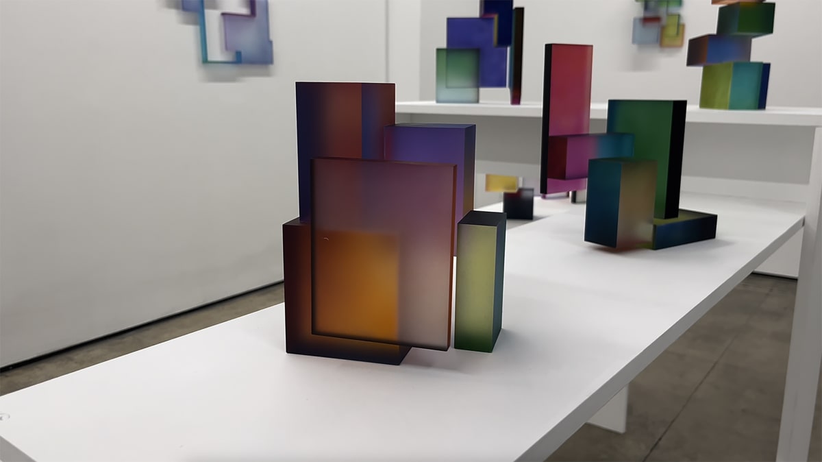 Colorful abstract sculptures by Greg Chann sitting on a table.