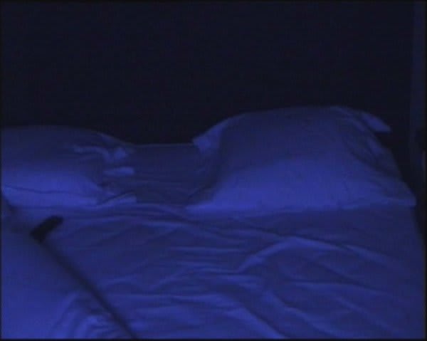 Pillows on a bed in violet light