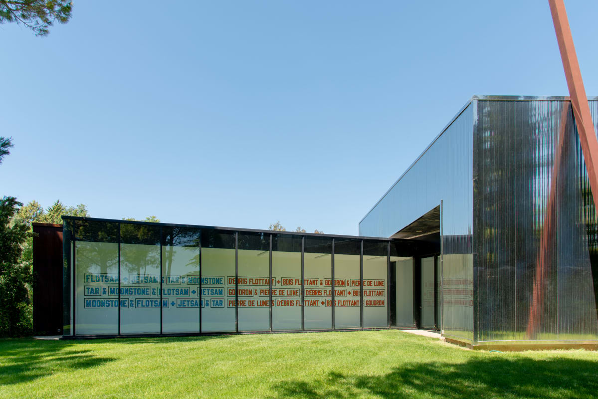 Installation view of a work by Lawrence Weiner at Venet Foundation in France; The statement reads, as follows, in both English and French: ⠀ ⠀ Flotsam + Jetsam + Tar + Moonstone ⠀ Tar + Moonstone + Flotsam + Jetsam⠀ Moonstone + Flotsam + Jetsam + Tar⠀ ⠀ D