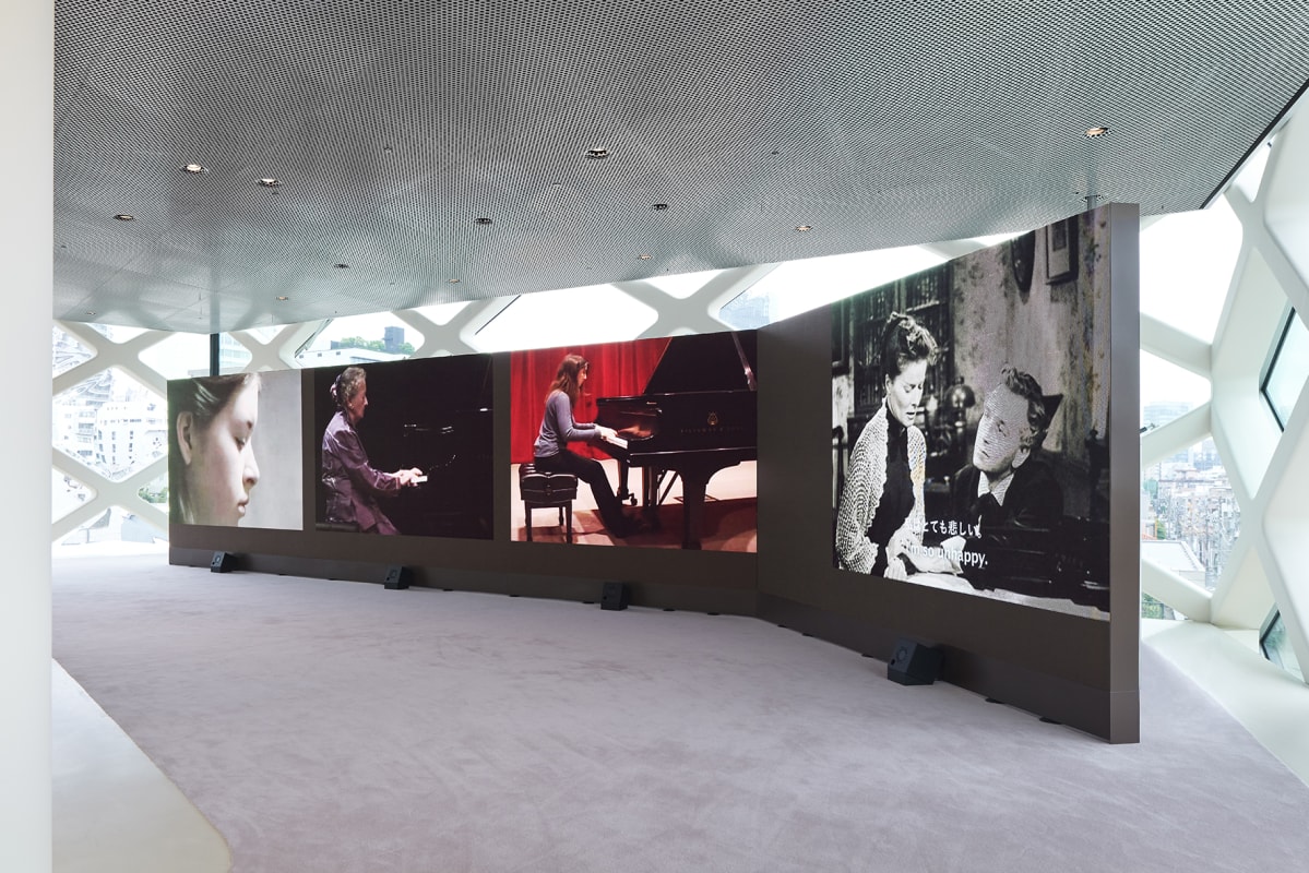 four screens with the work of Dara Birnbaum in Tokyo, at the Prada store in Aoyama; footage is of different girls playing the piano