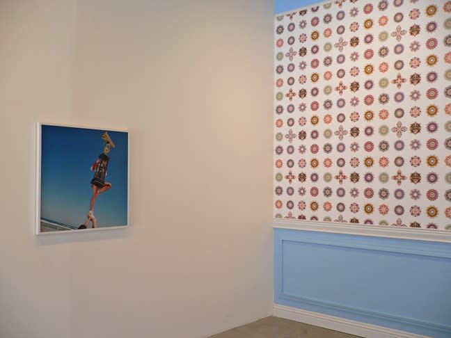 (left to right): Brian Finke. Cheerleader #2, 2001. Chromogenic print 30 x 30 inches. Cassandra C. Jones. Good Cheer, 2005/2006. Wallpaper, wood molding, and paint on wall. Site specific installation, dimensions variable.
