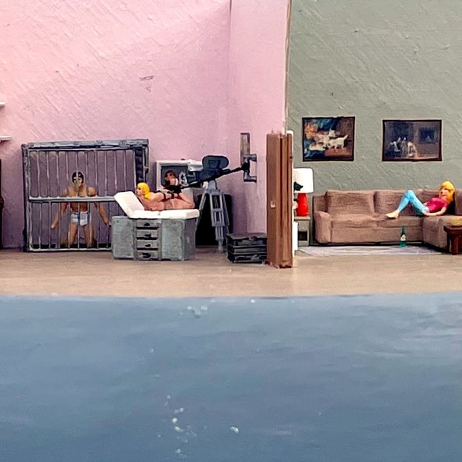 people tied up and locked in cages next to a room with a woman lounging on a couch