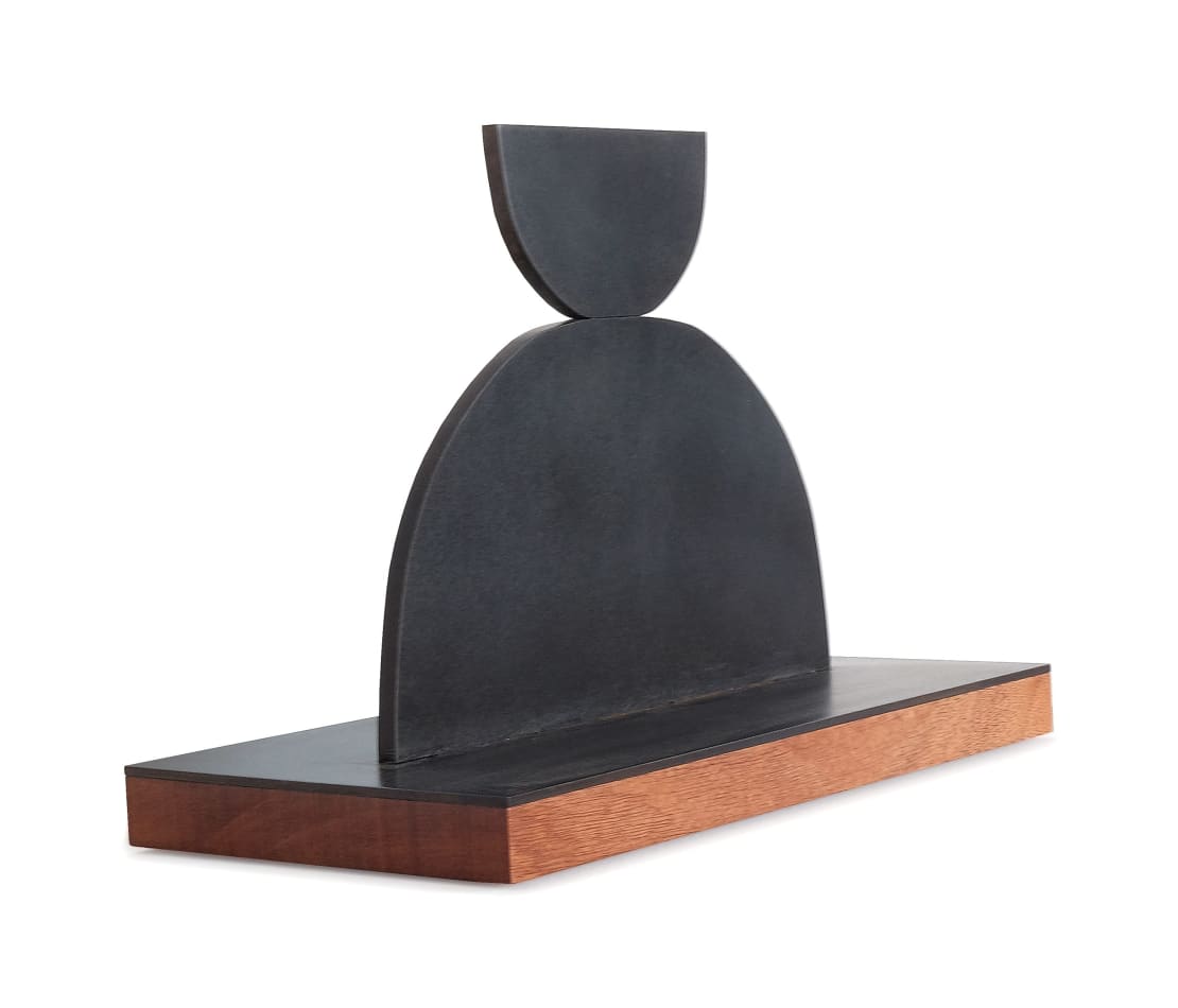 Scott Albrecht steel sculpture - two semi circles, smaller one balanced on larger one. Wood base - side view