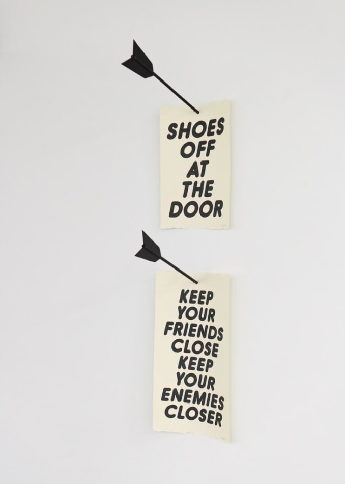 Two banner sculptures with large black arrows and text that reads: 