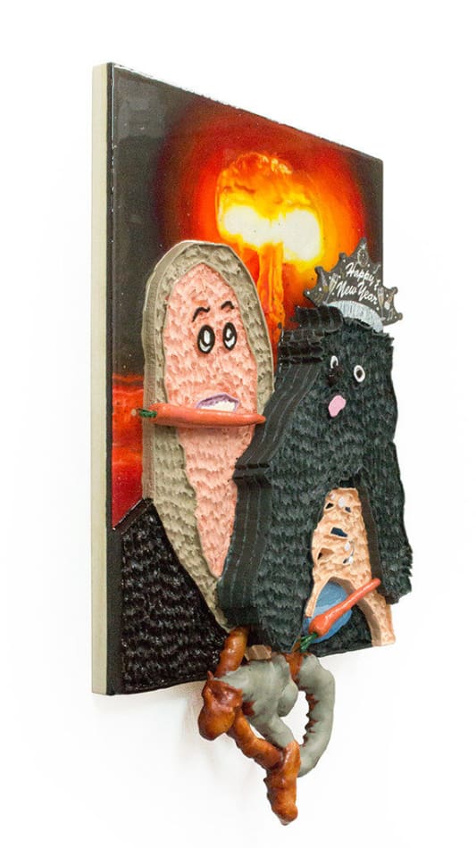 Mixed media hanging sculpture of a woman with a carrot in her mouth holding a small black dog with a Happy New Year paper crown on his head and a pretzel and a carrot in his hands. In the background an atomic bomb is going off.