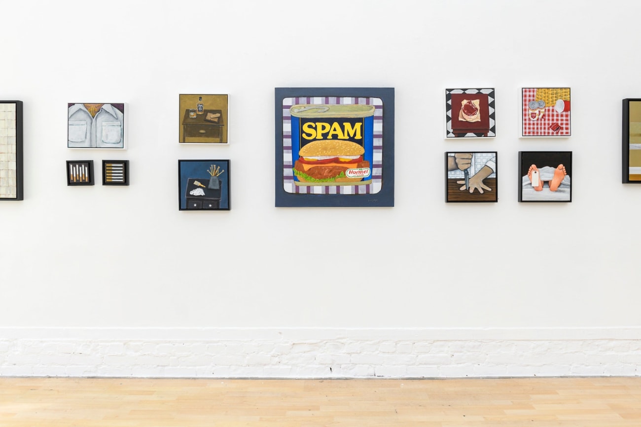 photo of various paintings hung on a white wall