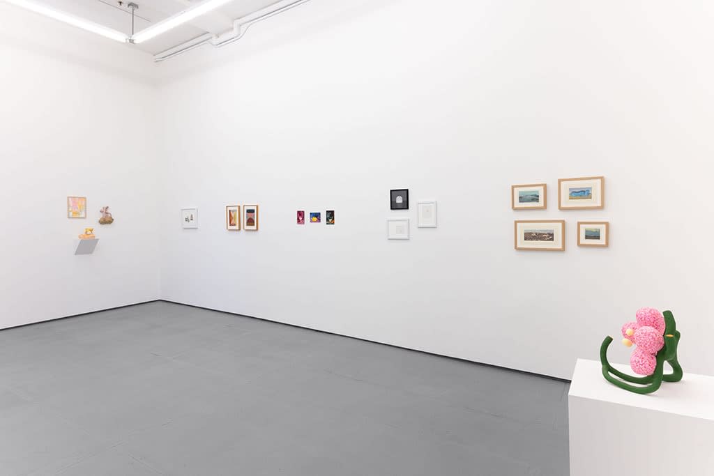 white gallery wall with small assorted artworks