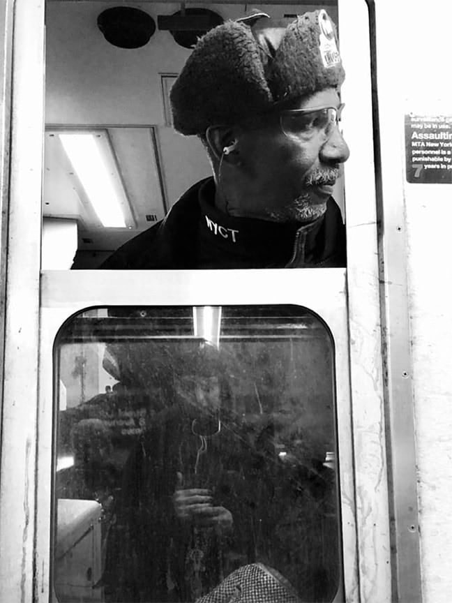 black and white photo of subway train conductor looking out the window