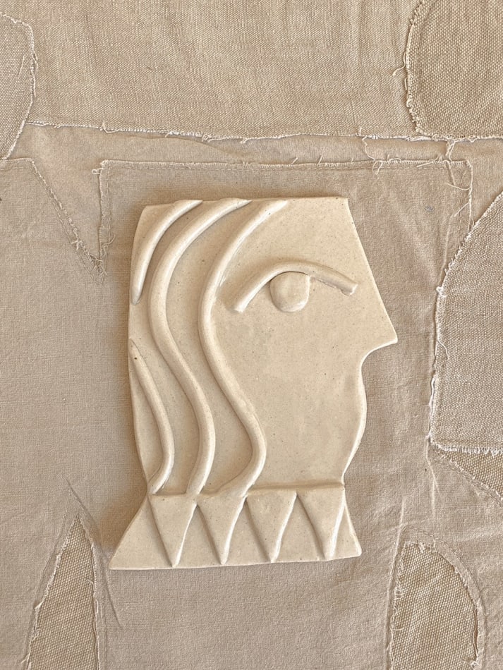 cream ceramic of side profile of a vase