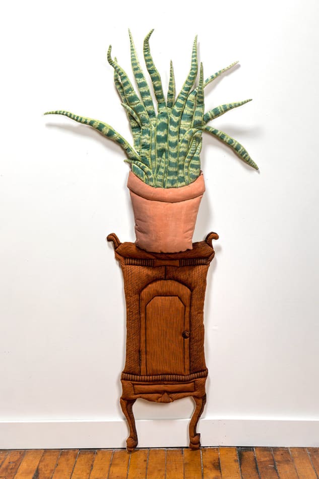 soft fabric sculpture of a potted snake plan on a wooden table