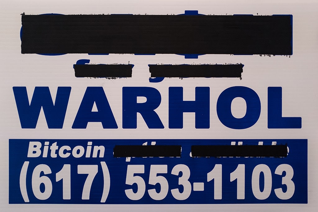 redacted sign reading warhol, bitcoin and a telephone number