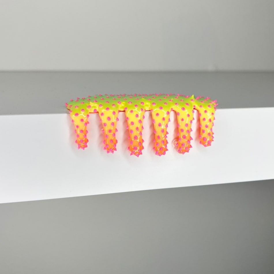 blob sculpture with green, yellow, and pink coloration