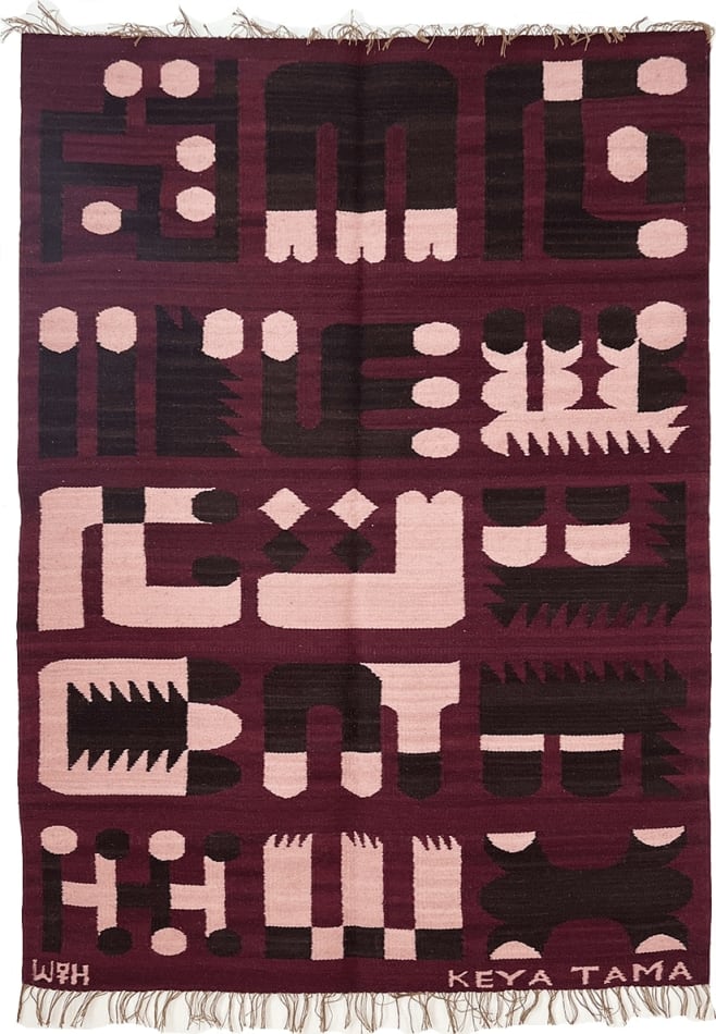 maroon knit blanket displaying abstract symbols by the art Keya Tama