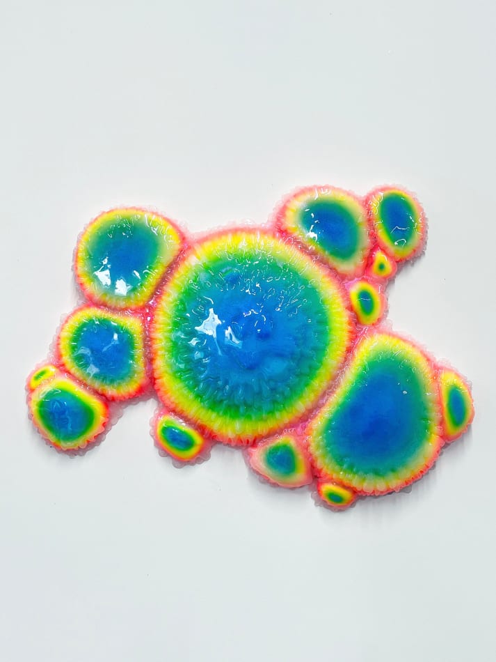 Sculpture with multiple circular objects with a rainbow gradient by Dan Lam