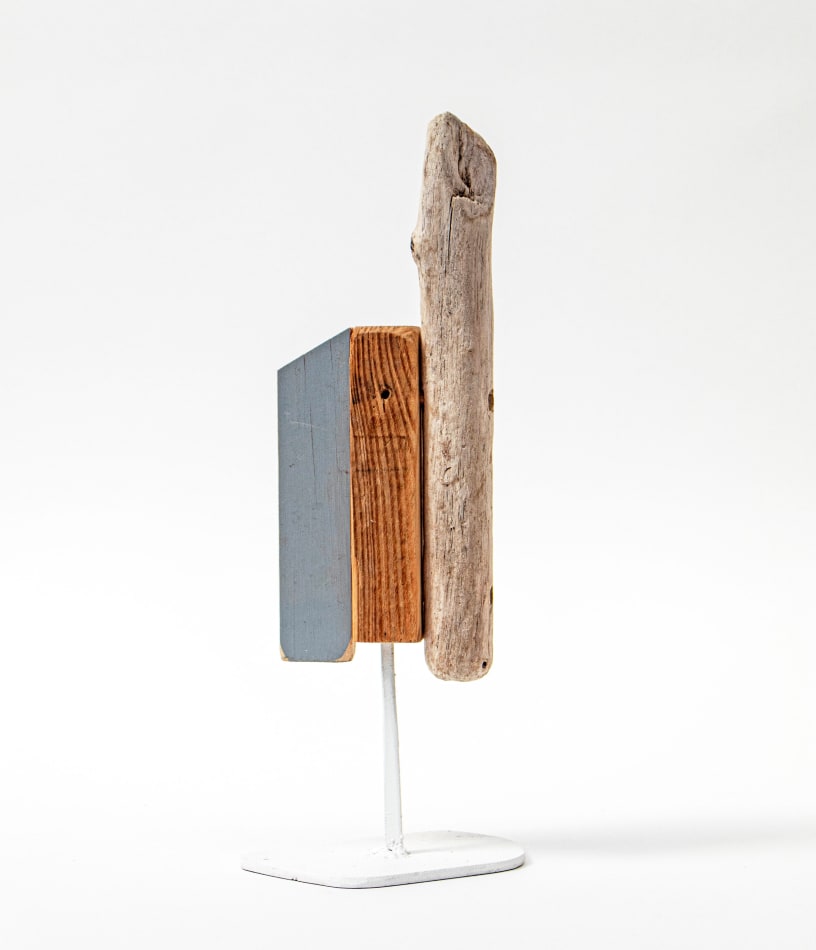 Wooden sculpture with a piece of drift wood and two other flat pieces of wood side by side on a metal stand by Hyland Mather
