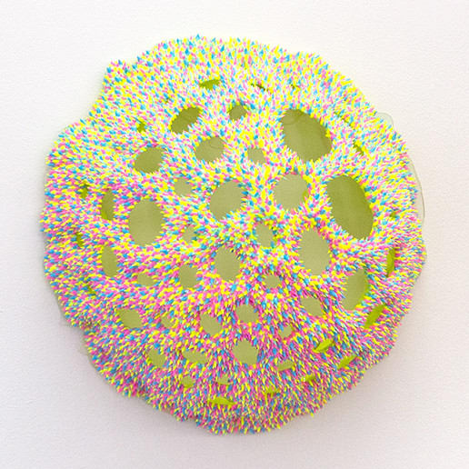 A sculpture by Dan Lam of a sphere with round holes broken through out the top of it.