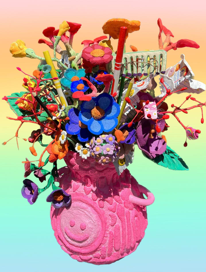 pink vase filled with flowers, markers and paper over a rainbow background