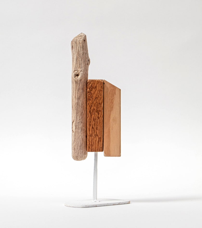 Wooden sculpture with a piece of drift wood and two other flat pieces of wood side by side on a metal stand by Hyland Mather