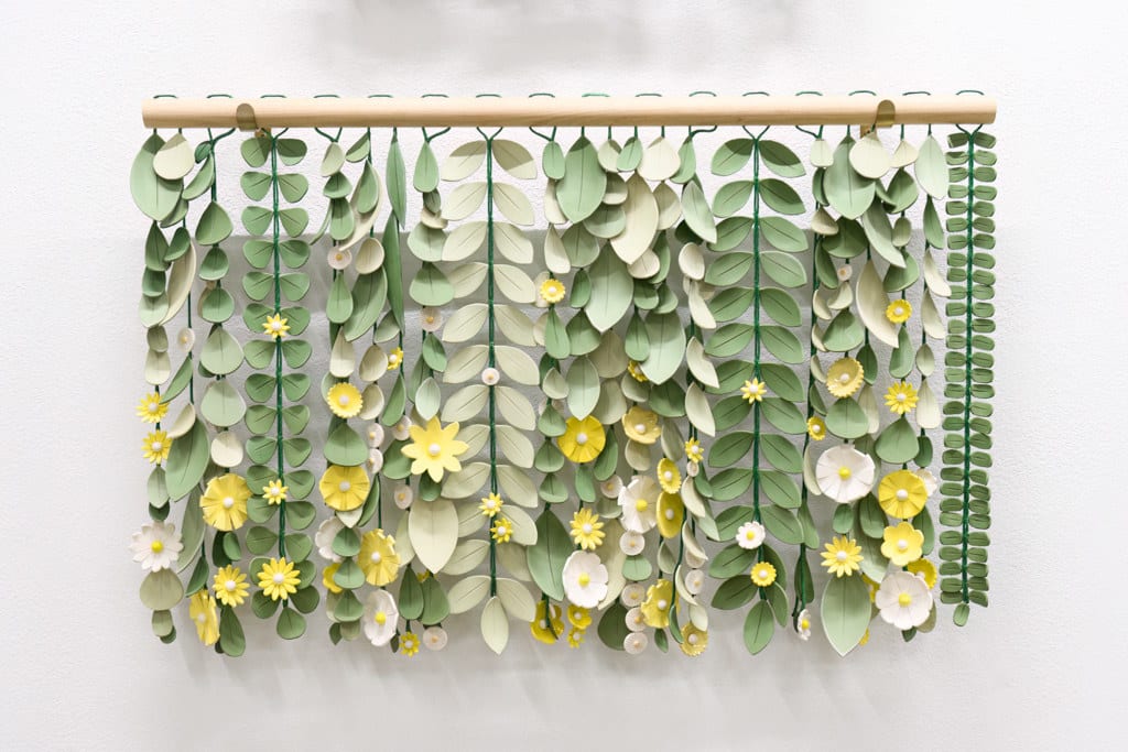 ceramic sculpture made up of dangling individual components that resemble leaves and flowers by artist Anastasia Tumanova