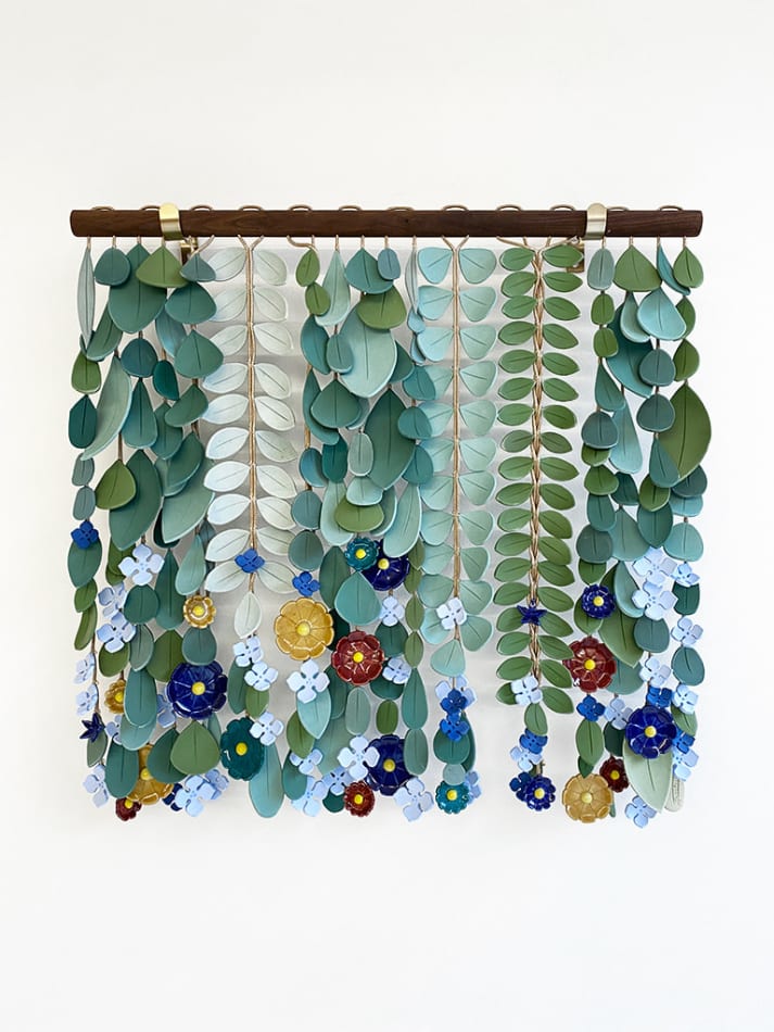 ceramic sculpture made up of dangling individual components that resemble leaves and flowers by artist Anastasia Tumanova