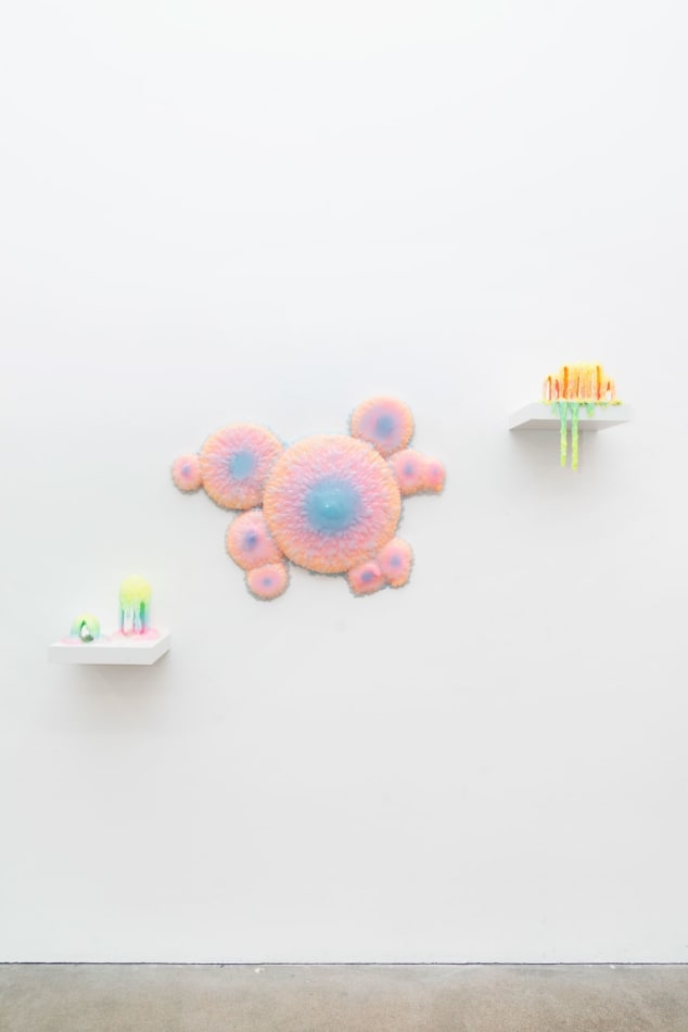 Installation shot of a sculpture with multiple circular objects with a pink to purple gradient by Dan Lam.