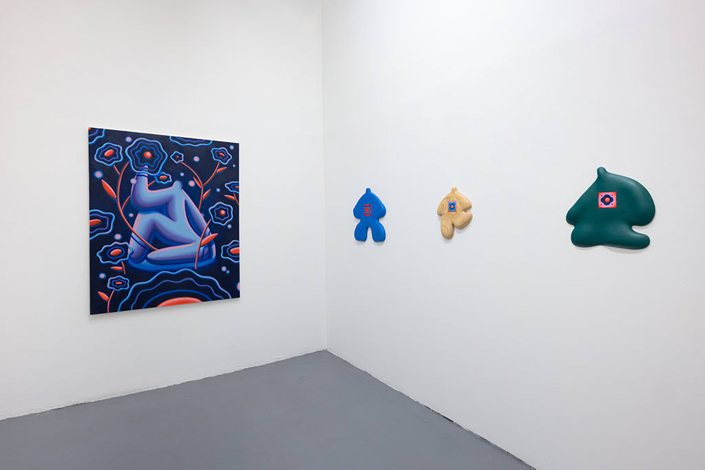 white gallery walls with a painting and colorful wooden figures by Jocelyn tsaih