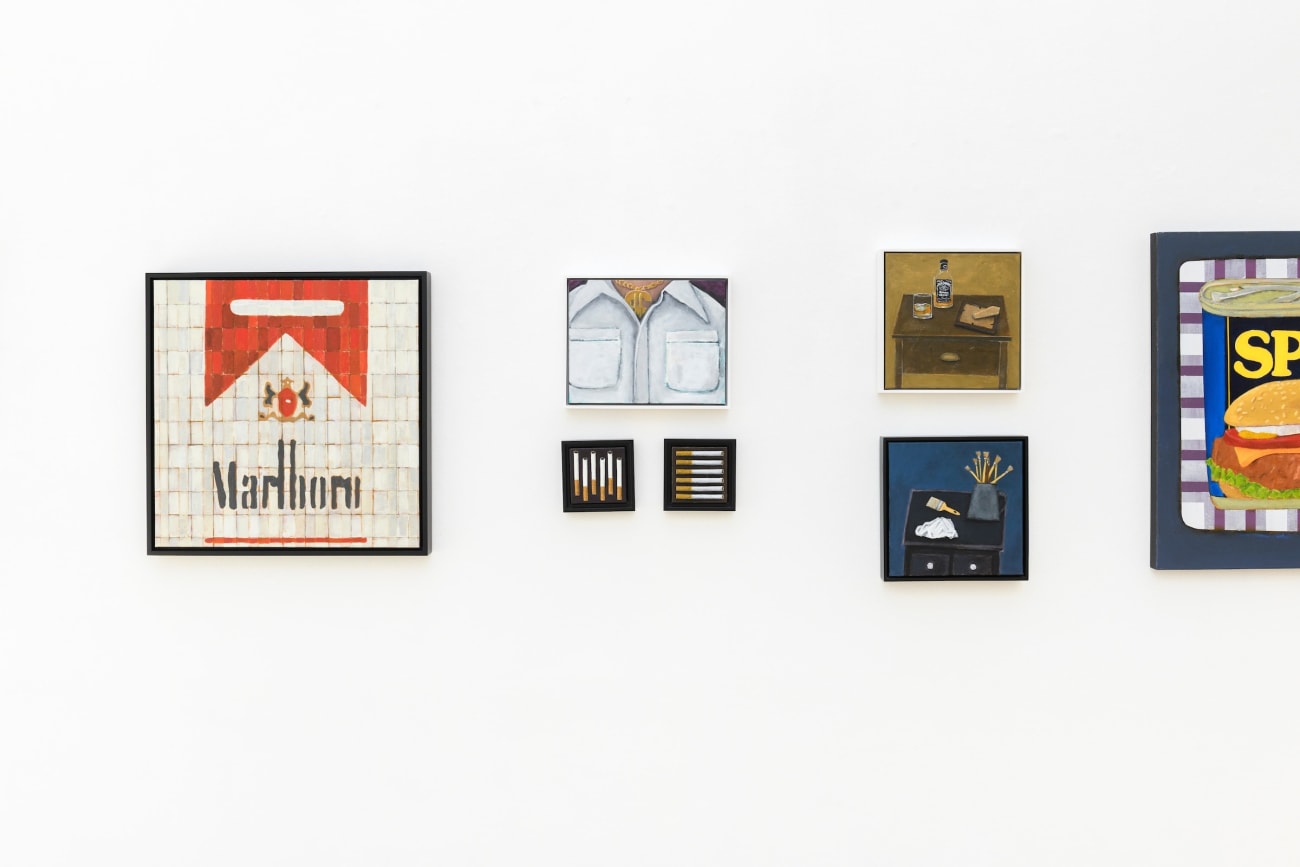 photo of a various paintings hung on a white wall