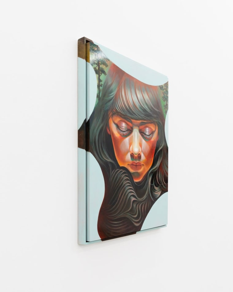 Portrait of a woman with dark brown hair and bangs facing the viewer with her eyes closed and her head turned down. There are trees in the background and an abstract blue shape creating a border around her face.