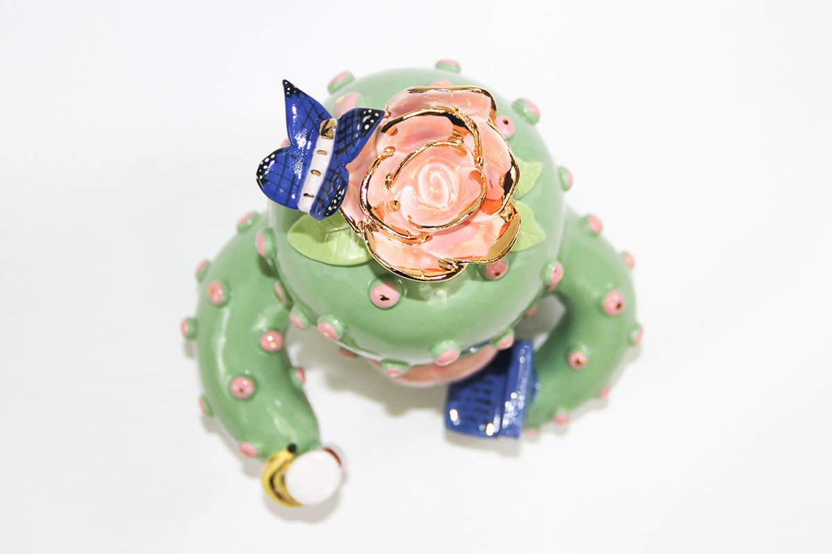 aerial view of Jen Dwyer sculpture of green cactus with pink lips holding laptop, banana and Nutella jar