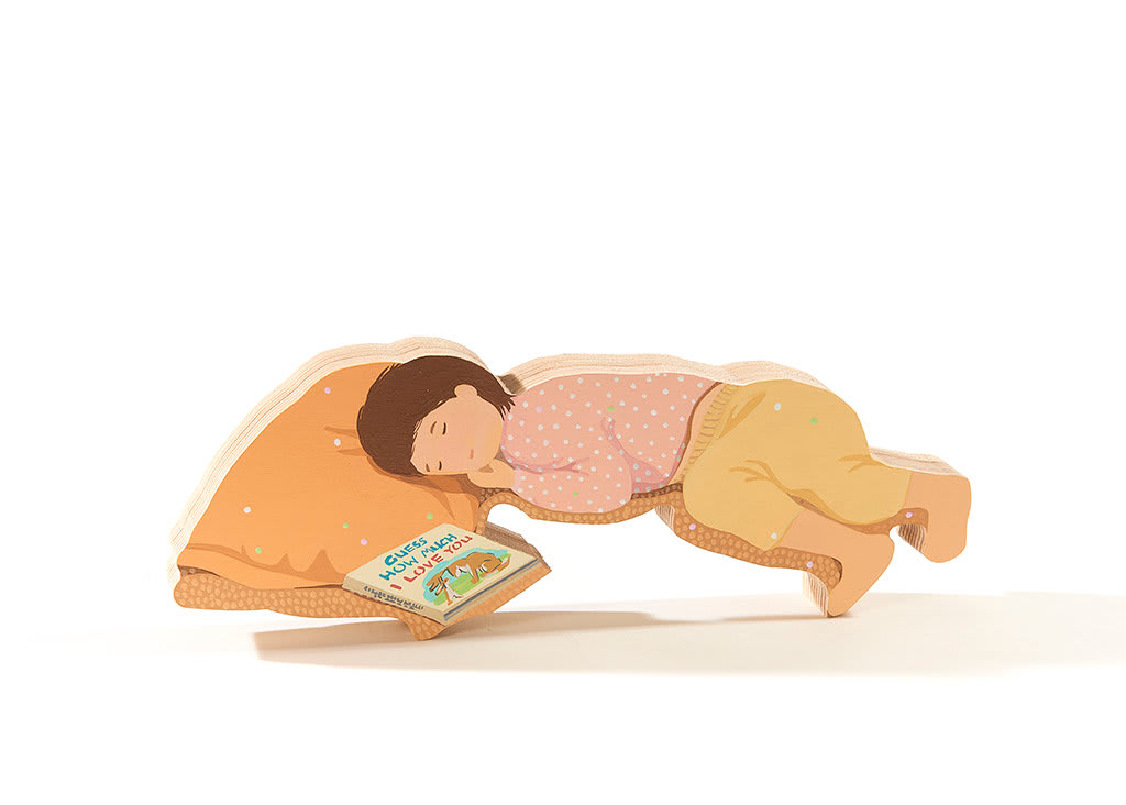 a child laying down asleep with the book guess how much I love you next to them