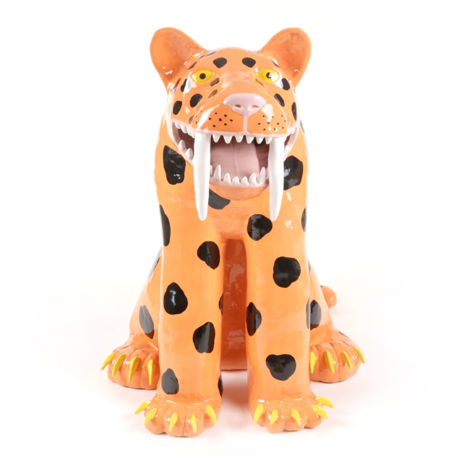 ceramic sculpture of a smiling sabertooth tiger with large black polka dots