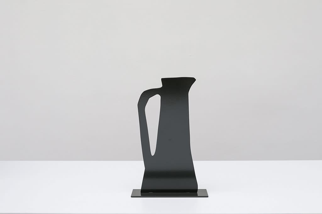 Metal sculpture of a black jug with a handle