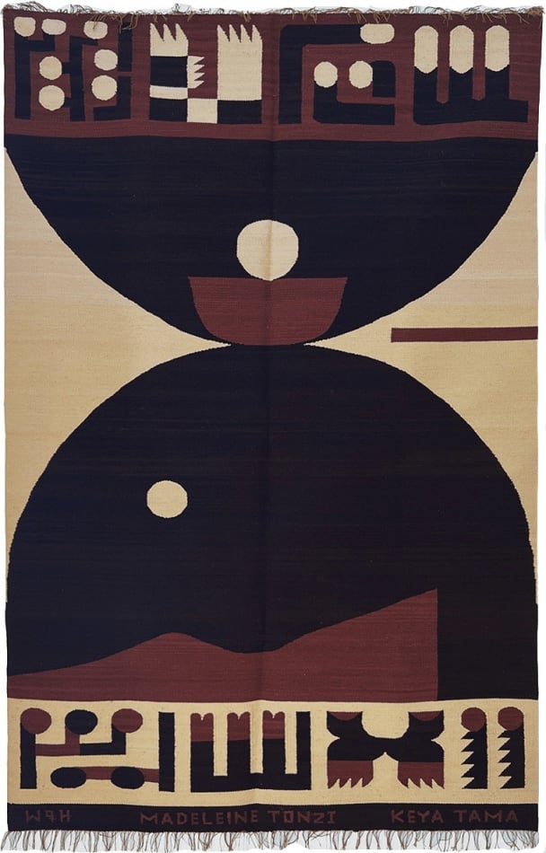 collaborative knit rug decorated with two half circles and abstract symbols